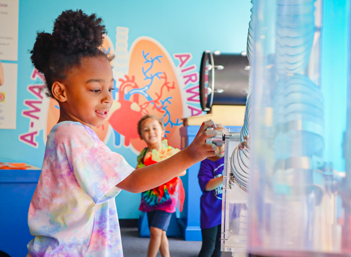 A little girl is playing with an interactive museum exhibit