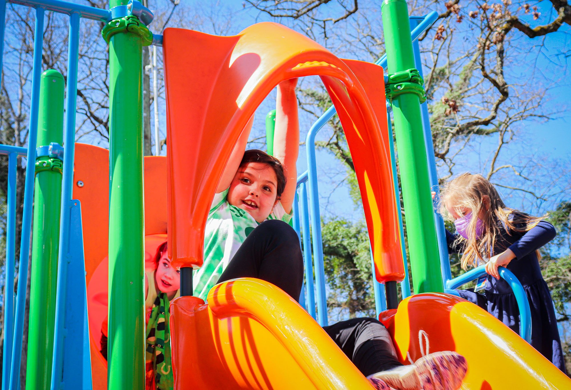 A young child playing on a slide outside